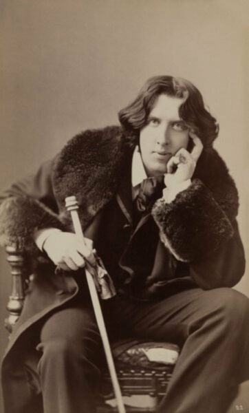 Napoleon Sarony, Oscar Wilde, 1882, albumen print on card mount, 30.6 x 18.4 cm, Prints and Photographs, United States Library of Congress, Wikimedia Commons. Oscar Wilde is pictured here with a fur-trimmed coat.