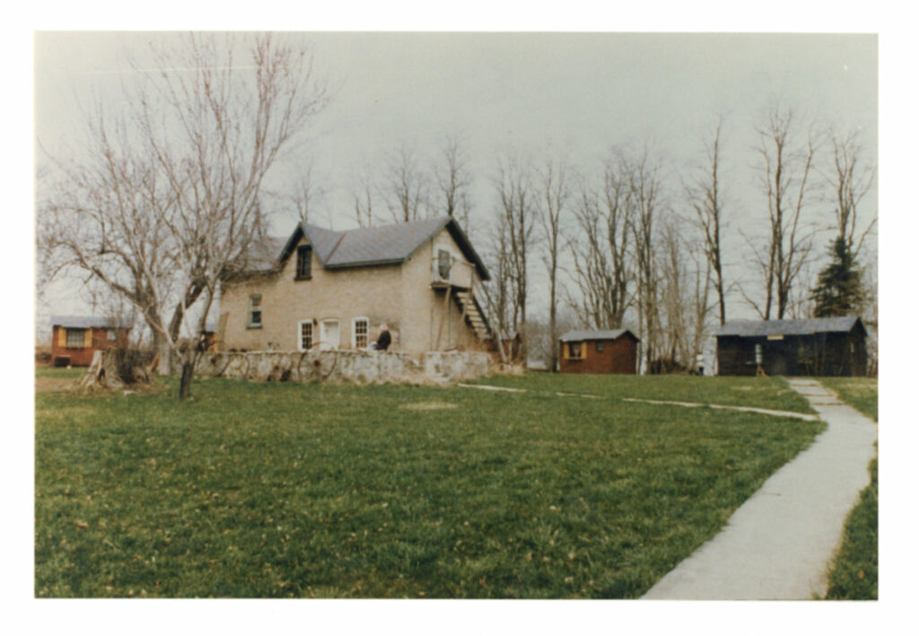 The coach house in 1980 prior to the purchase of the property by the City of Kitchener. The bath house and cabins can be seen in the background.